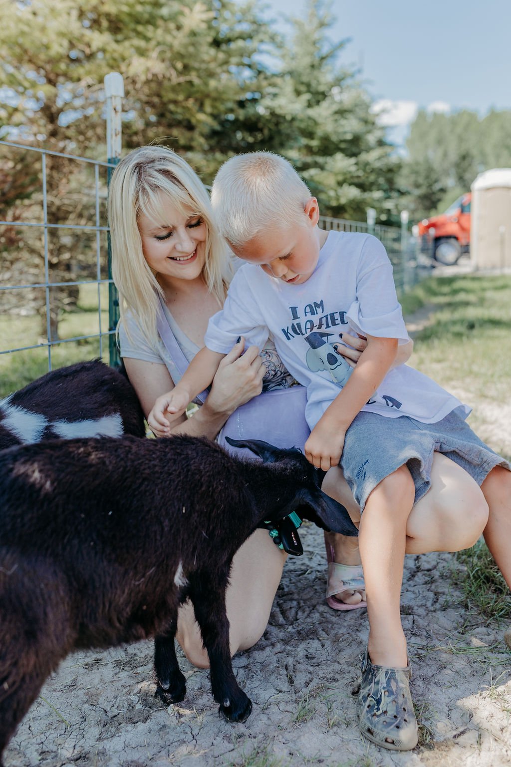 Mother and son enjoying themselves at petting zoo.